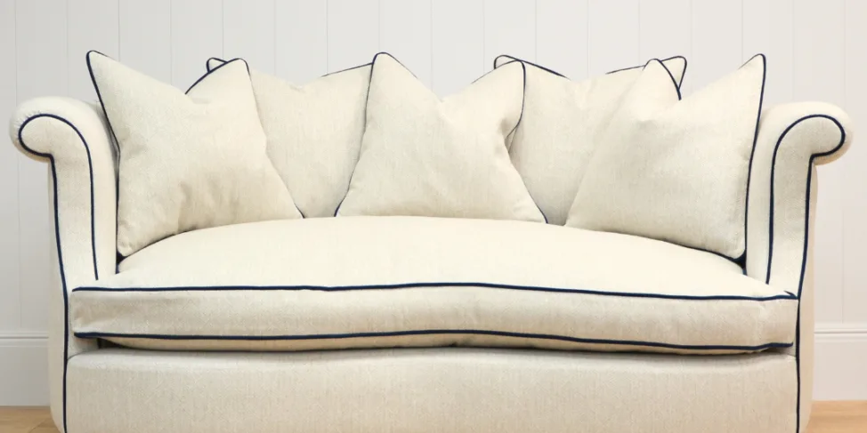 Curved Sofa Reupholstered in a Cream Fabric with Dark Contrast Piping